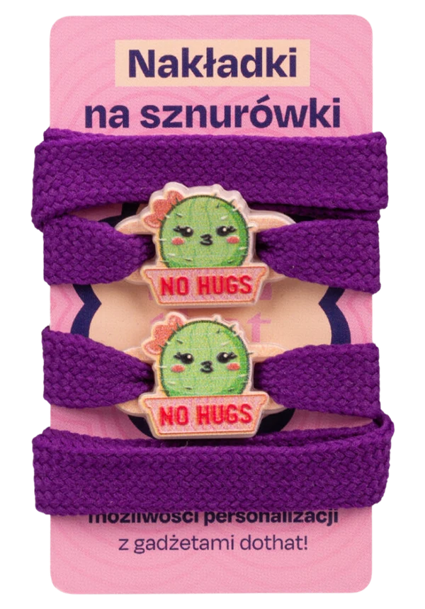 Dwie nakładki na sznurówki z kaktusem No Hugs na kartoniku z fioletowymi sznurówkami