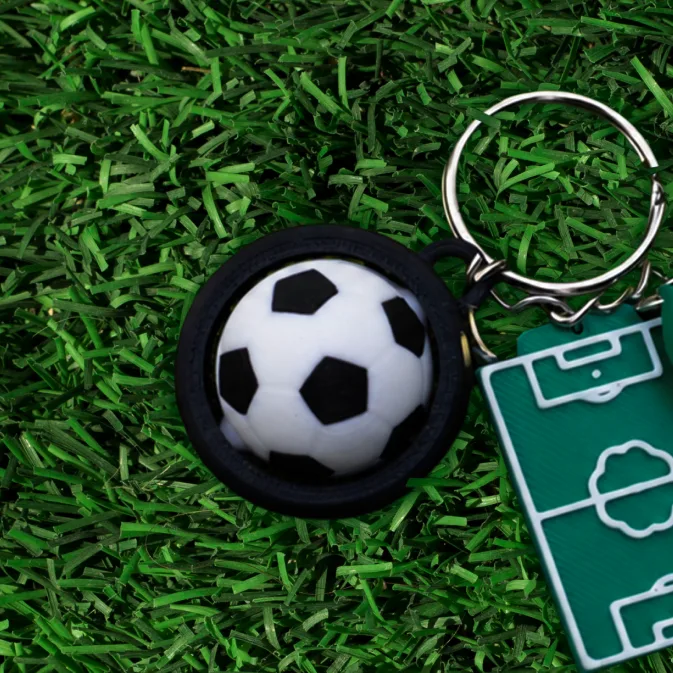 Moving 3D promotional keychain with a spinning football and pitch