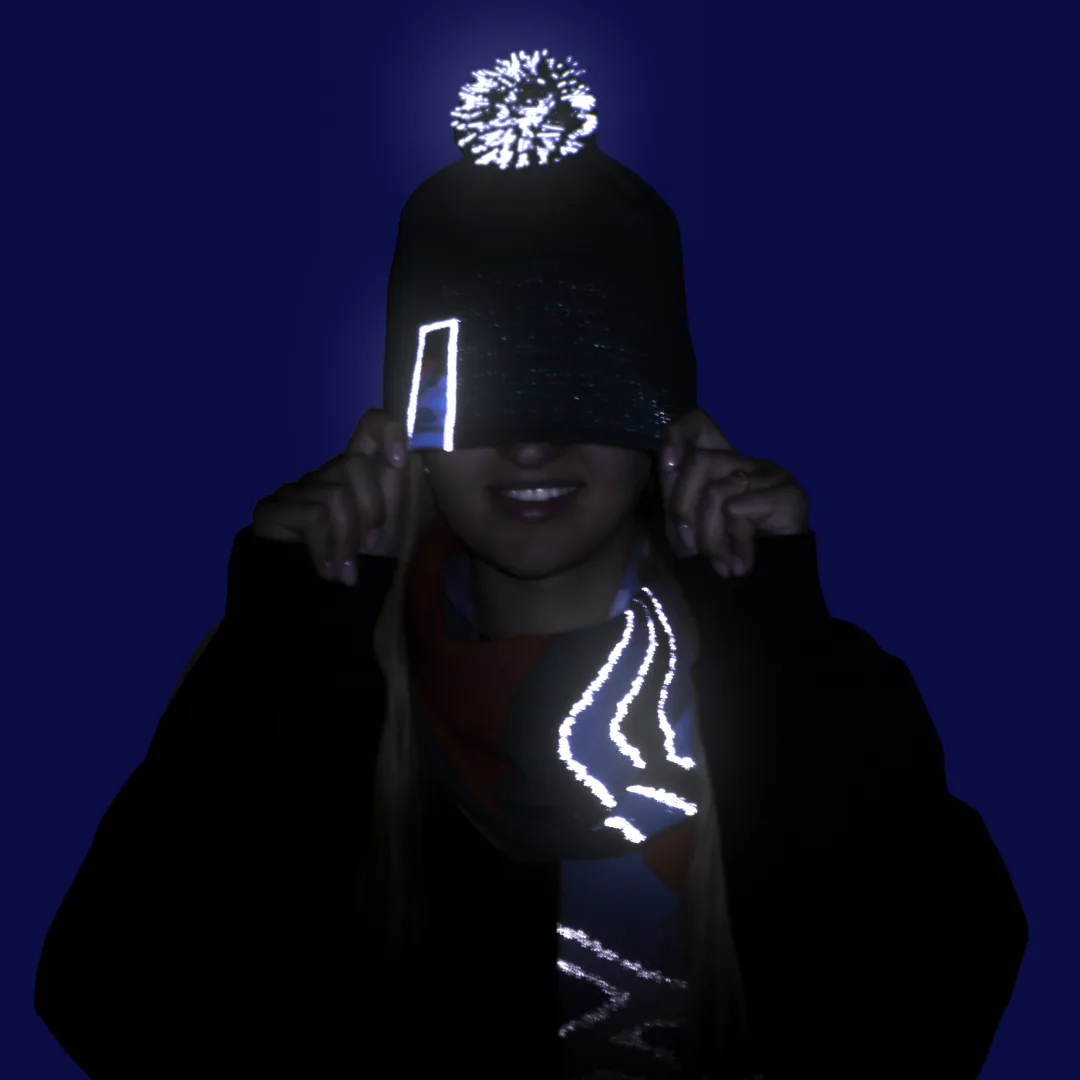 The same hat and scarf after dark – the reflective yarn shines in the headlights